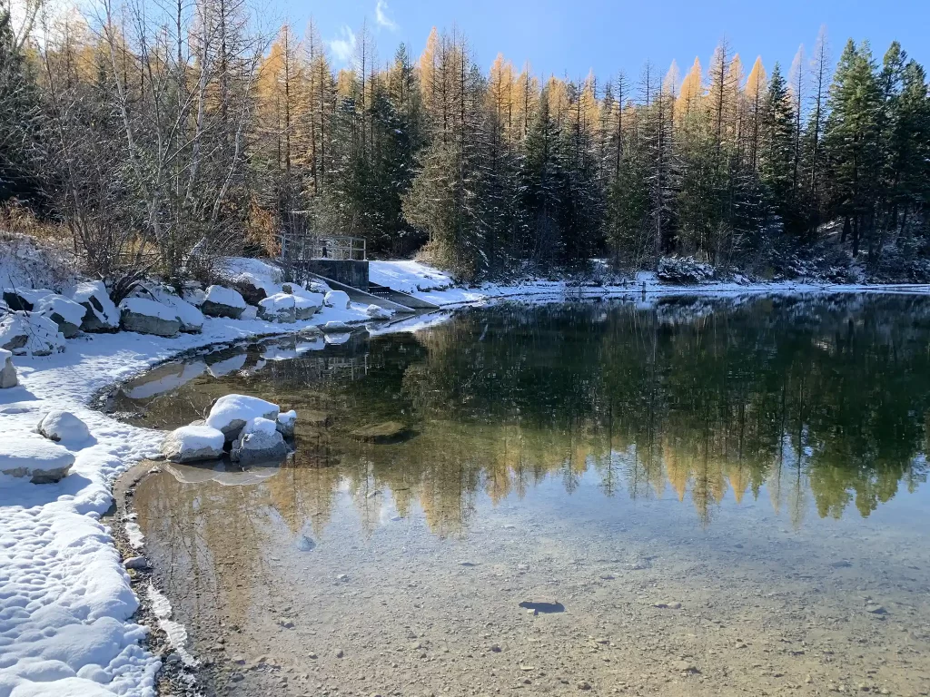 USFS lake dam in winter with snow around the lake.