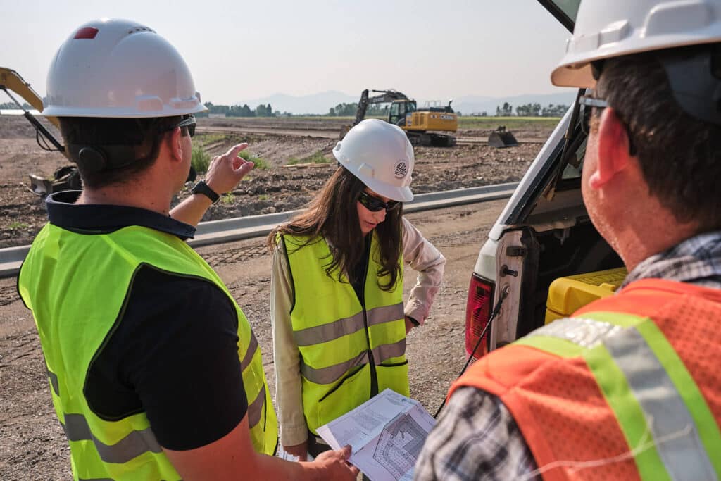Three engineers planning at a subdivision civil engineering project.