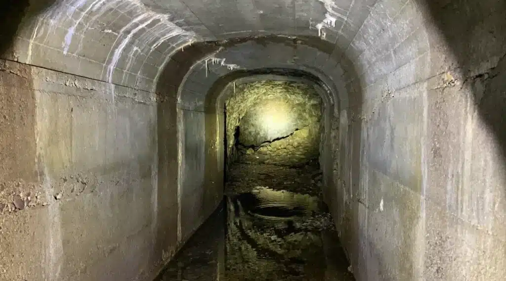 Route of the Olympian Culvert Evaluation of tunnel lit with a flashlight.